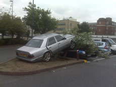 car on fence outside Morrisons in Acton