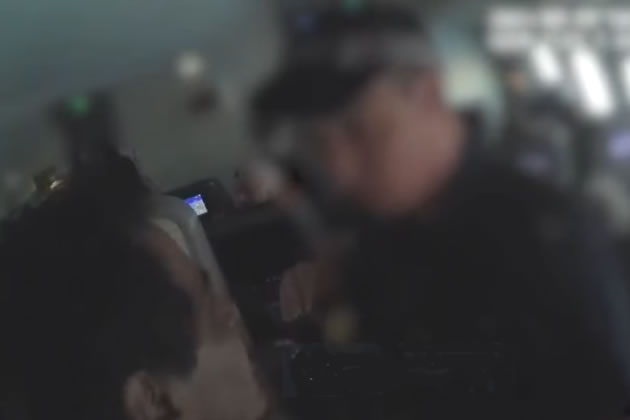 Aghgaleh being escorted off the plane at Heathrow