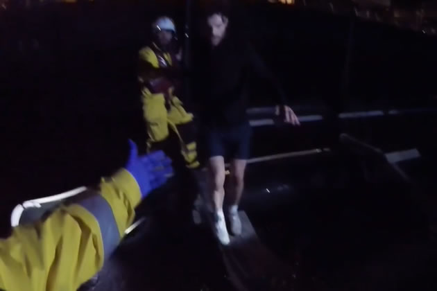 Jordan being helped off the pontoon after the dog was rescued