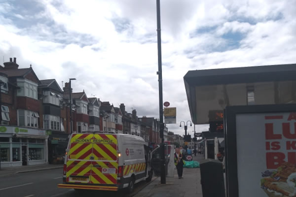 A TfL officer from the Bus Support Division quickly on site at 12.25pm to take down the closure and diversion Bus Stop signs on Turnham Green Terrace for the E3 buses. The first bus down the road can be seen in the background going Southbound. Great Co-Ordination. The technology in use was a long pole! 